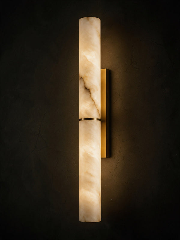A slim alabaster tube wall light on a brass bracket