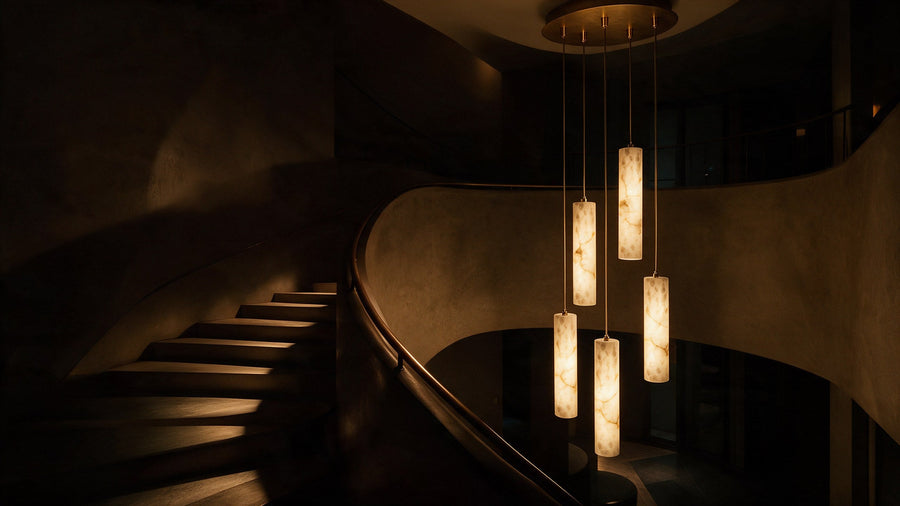 A double-height stairwell with a tall alabaster pendant composition